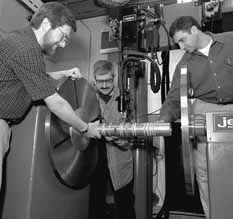 Eric Zimmerman, Larry Bartoszek and Ioanis Kourbanis examine welding sample at the machine that will weld the MiniBooNE and NuMI horns