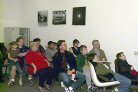 The audience in Wilson Hall's Virtual Reality room learned about neutrinos, and donned special polarizing spectacles to view the 3-D simulations.