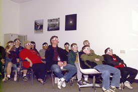 The audience in Wilson Hall's Virtual Reality room learned about neutrinos, and donned special polarizing spectacles to view the 3-D simulations.