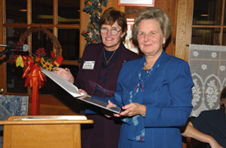 Jane Monhart (left), U.S. Department of Energy Area Manager for Fermilab presents the Proclamation naming Andy's Pond to Joan Mravca, at the October 29 DOE Area Managers National Conference at Fermilab.