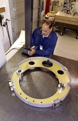 Sudhir Ghanta measures a suspension support assembly for the LHC IR quad project. The Quality Control Group uses several kinds of coordinate measuring machines, including an Avant Video Measuring System, which is accurate to within about four microns.