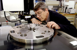 Steve Merkler, measuring a coldmass end plate for the LHC IR Quad project, has more than twenty-two years of experience.