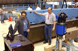 Oscar Lira (left) and Ted Beale use the Laser Tracker to compare the straightness of a B2 dipole magnet in various orientations, ensuring tight tolerances for NuMI's primary proton beam.