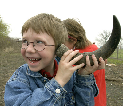 Owen Crawford, 7, gets the inside scoop as Don Hanson describes his role as herdman for Fermilab's American Bison.