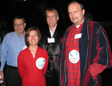 Fermilab Deputy Director Young-Kee Kim poses in her red footy pajamas with CMS scientist Joel Butler, accelerator scientist Joe Lykken (in silk robe) and CMS scientist Lothar Bauerdick (in full robe and pajamas at right).