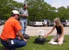 Christie Brayer shows a mosquito trap to Mike Becker and Mark Schiltz