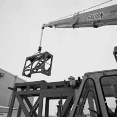 The crane truck carefully lowers a side section into place atop the 25-ton base.