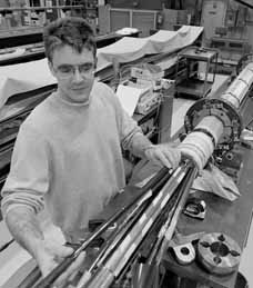 Paul Mayer checks one of the leads to a coil prior to final assembly of the magnet