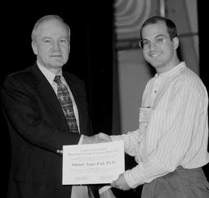 Michael Fitch (right), University of Rochester, receives the Fermilab/URA Thesis Award from Fred Bernthal, president of URA