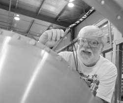 Len Bugel, working on the MiniBooNE horn, teaches physics at the Stratton Mountain School in Vermont. 'My job as a physics teacher is to teach physics, sure, but it's also to let kids know that physics is interesting. Many introductory physics courses do not make physics very interesting.'