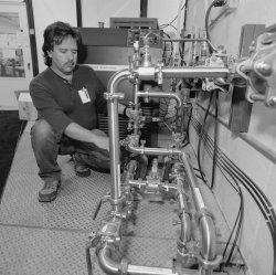 Camilo Espinoza, mechanical technician from Los Alamos, checks the oil plumbing system that he designed for the MiniBooNE detector. By circulating oil through a heat exchanger, scientist can maintain the oil at a constant temperature fo about 60 degrees.