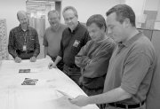 Rich Schmitt, Bruce Lambin, Bryan Johnson, Rodney Choate and Jeff Duncan check over engineering drawings at Femrilab.