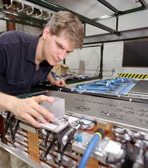 Using an alignment sensor box, Robert Lee checks a muon chamber before shipment to CERN.