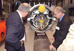 Fermilabs Mike Lamm (right) shows Marburger a superconducting magnet headed for the LHC at CERN, the European Particle Physics Laboratory in Geneva, Switzerland.