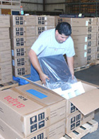 Alex Hernandez of Computing Divisions Equipment Support unpacks PCs and inspects them for damage.