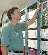 BooNE cospokesperson Bill Louis checks the MiniBooNE data acquisition system. Louis is a scientist at Los Alamos National Laboratory. In the 1990s, he worked on the LSND experiment, which triggered the idea for the MiniBooNE experiment.