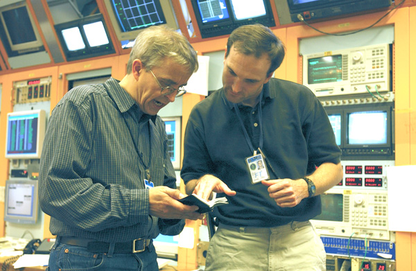 Frank Schmidt,an accelerator physicist from CERN,(left) and Dean Still of Fermilabs Tevatron Department,(right) took shifts together in the main control room at Fermilab.This is a very hard-working team here, and [the collider run] is moving along well, Schmidt said.