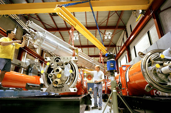 Workers in Fermilab's Technical Division complete the final assembly of superconducting quadrupole magnets for the interaction regions of CERN's Large Hadron Collider in Switzerland.