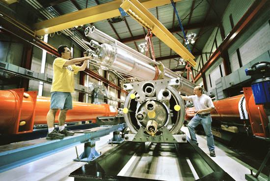 Workers in Fermilab's Technical Division complete the final assembly of superconducting quadrupole magnets for the interaction regions of CERN's Large Hadron Collider in Switzerland.