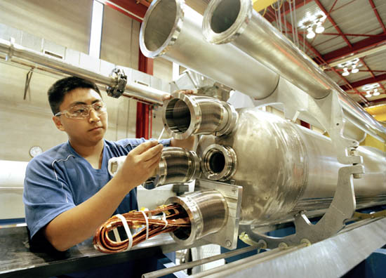 A technician cleans a sealing surface prior to applying a vacuum in order to leak-check a superconducting quadrupole magnet built by Fermilab's Technical Division for the Large Hadron Collider at CERN.
