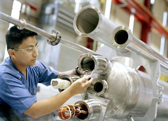 A technician cleans a sealing surface prior to applying a vacuum in order to leak-check a superconducting quadrupole magnet built by Fermilab's Technical Division for the Large Hadron Collider at CERN.