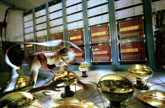 A summer student working on the MiniBooNE experiment inspects one of the phototubes that detects light from neutrino interactions.