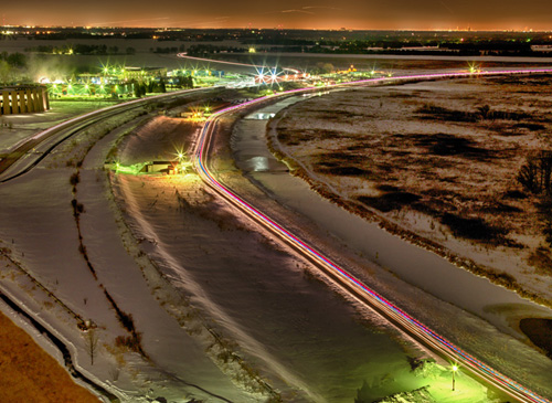 Vehicles with lights circle the Tevatron ring at night